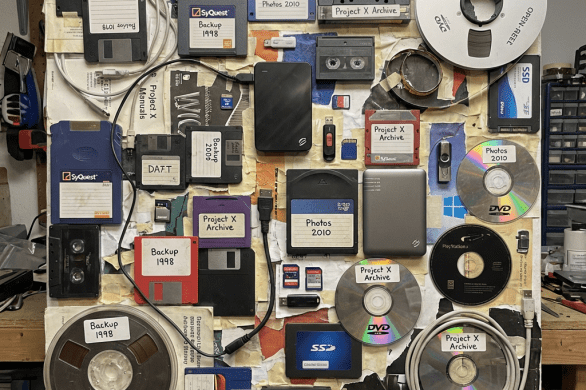 An organized display of data storage media including floppy disks, tapes, CDs, and hard drives.